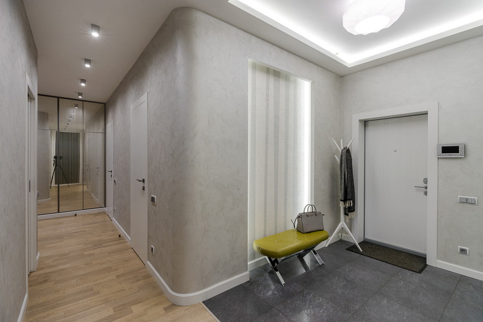 На фото интерьер г-образного коридора в квартире с разным типом освещения