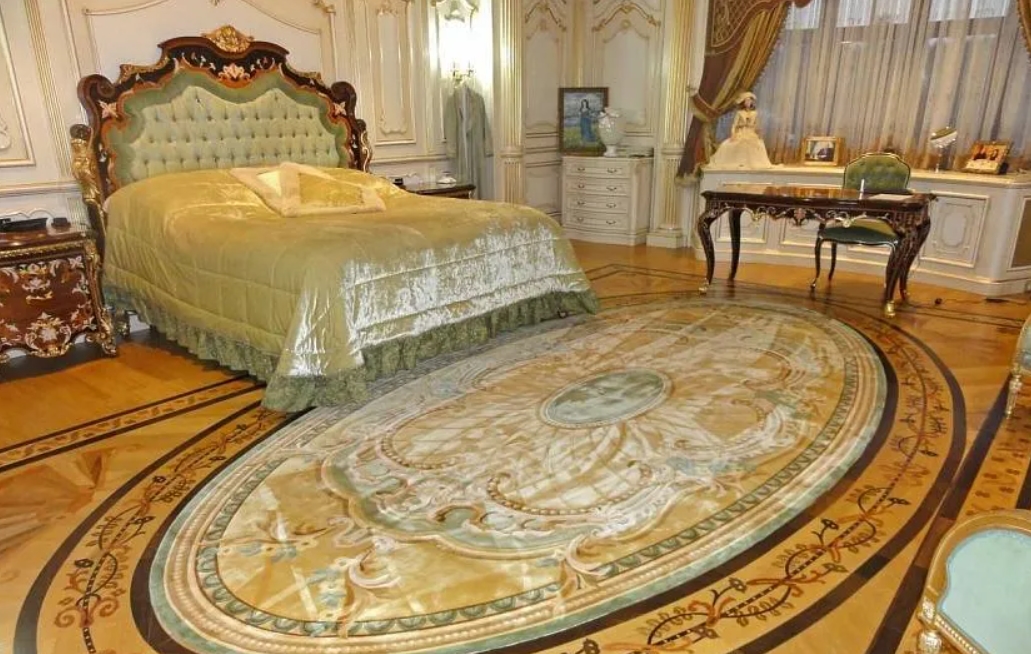Спальня, оформленная в стиле рококо с ковром перед кроватью